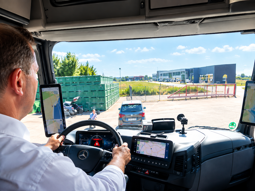 Blick aus dem Fahrerhaus eines modernen LKW auf Lenkrad, Displays und Assistenzsysteme.